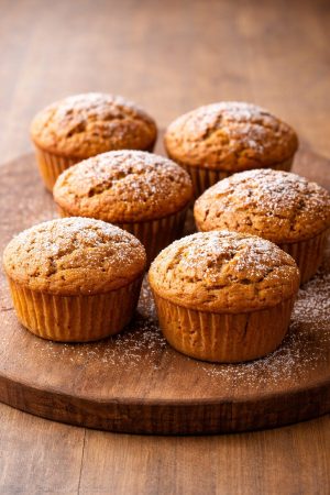 Freshly baked pumpkin muffins on wood