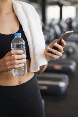 Gym break with water and smartphone